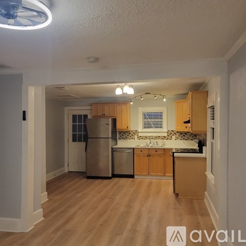 A kitchen with wooden cabinets and a refrigerator.