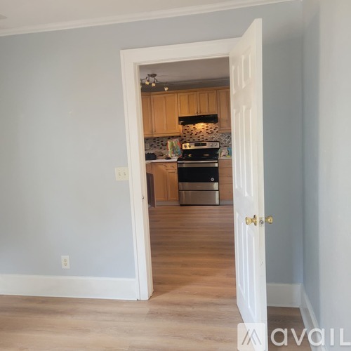 A kitchen is visible through an open door.