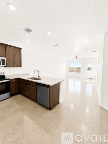 A modern kitchen with brown cabinets and a white countertop.