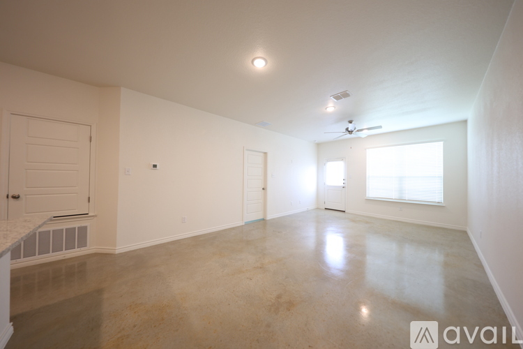 A spacious room with a marble floor and white walls.