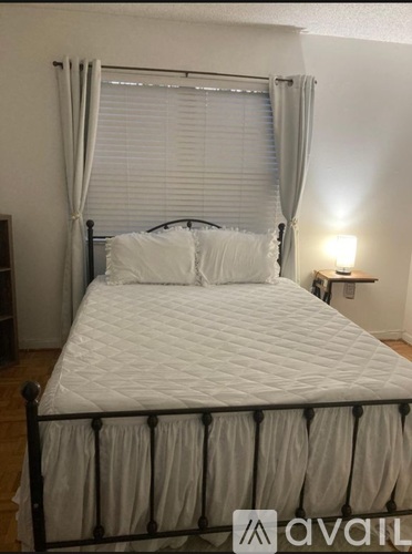 A white bed with a grey canopy and pillows.