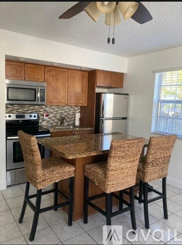 A kitchen with a table and chairs.