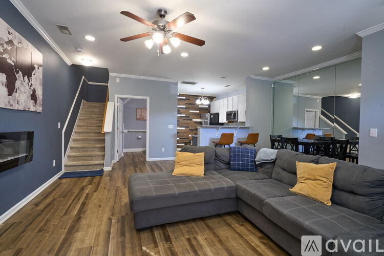A living room with a grey sofa and a ceiling fan.