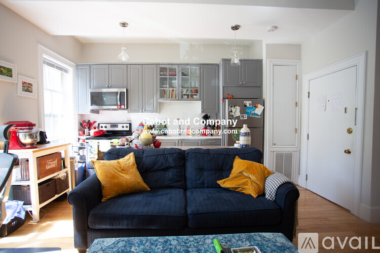 A living room with a black couch and a coffee table.