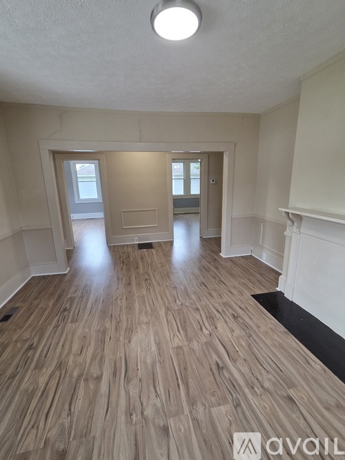 A room with wooden flooring and white walls.