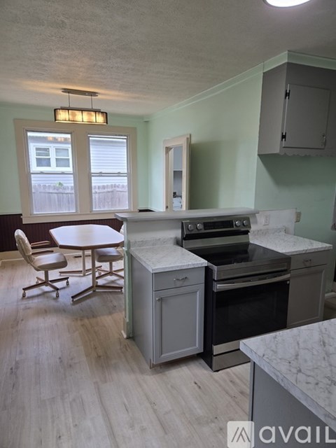 A kitchen with a table and chairs and a stove top oven.