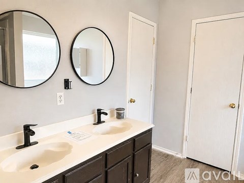 A bathroom with two sinks and two mirrors.