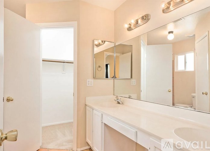 A bathroom with a sink, mirror, and lighting fixtures.