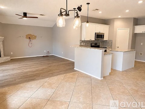A kitchen with a white counter and cabinets is shown.