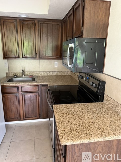 A kitchen with wooden cabinets and granite countertops.