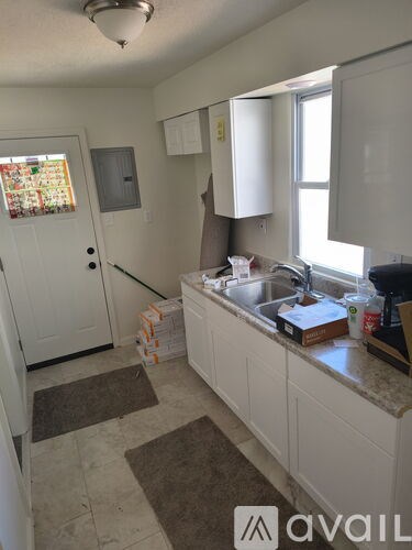A kitchen with white cabinets and a sink.