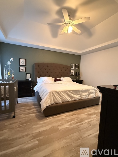 A bedroom with a large bed and a ceiling fan.