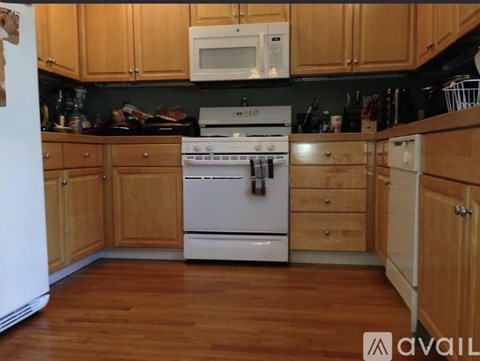 A kitchen with wooden cabinets and a white fridge.