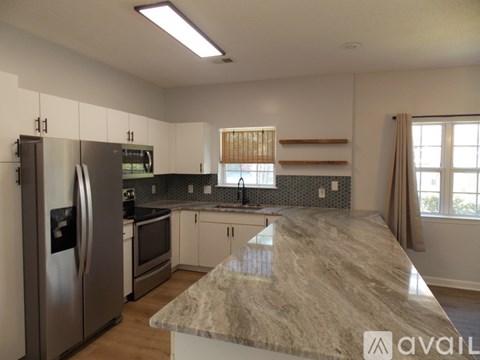 A kitchen with a granite countertop and stainless steel appliances.