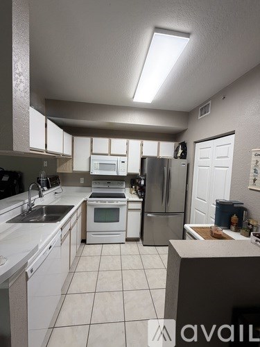 A kitchen with white cabinets and appliances.