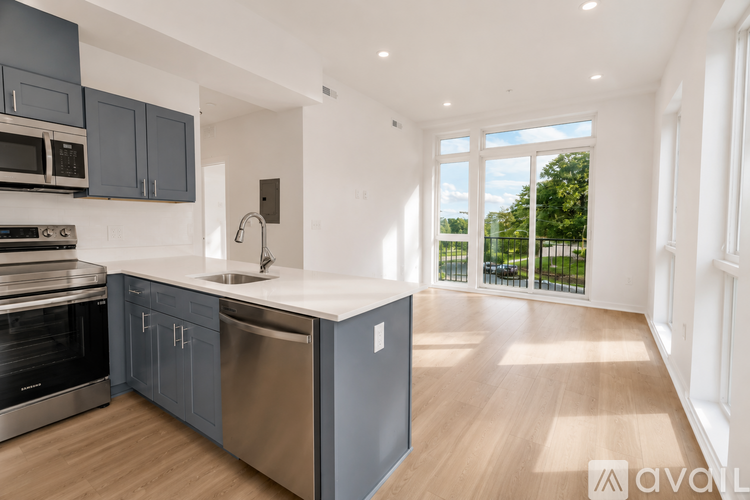 A modern kitchen with dark grey cabinets and stainless steel appliances.