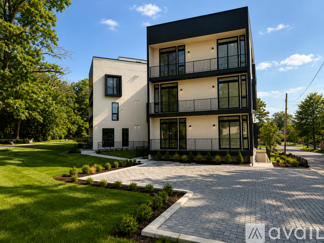 A modern two-story house with a black and white exterior and a balcony on the second floor.