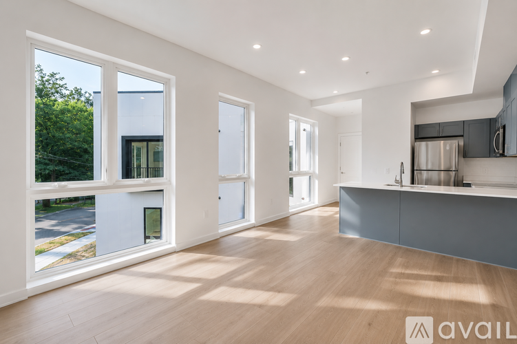 A spacious, well-lit room with wooden floors and large windows.