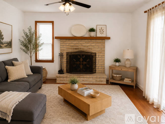 A living room with a fireplace and a grey couch.