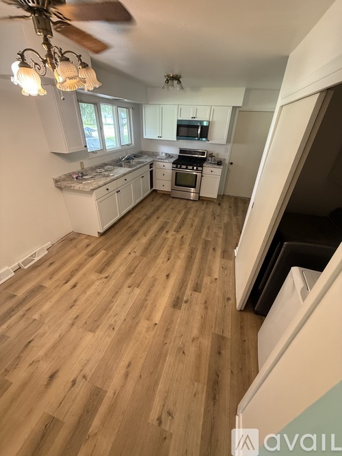A kitchen with wooden floors and a ceiling fan.