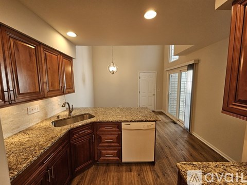 A kitchen with wooden cabinets and granite countertops.