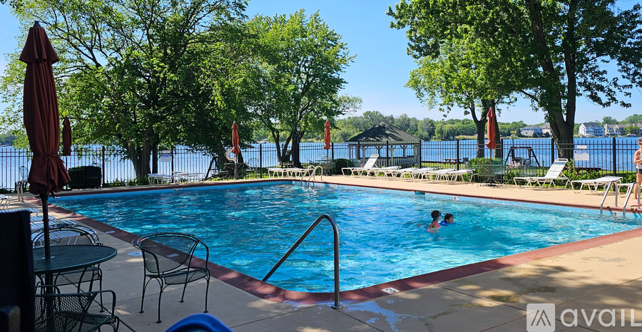 A pool with a table and chairs and umbrellas.