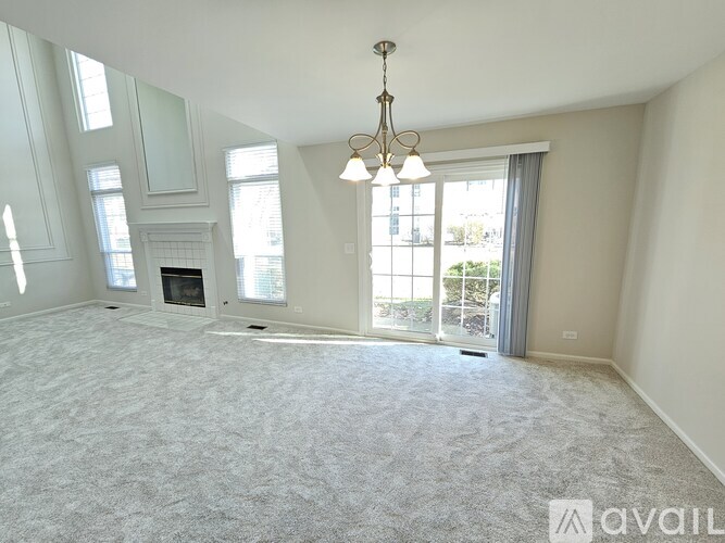 A spacious living room with a fireplace and large windows.
