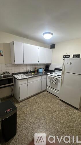 A kitchen with white appliances and cabinets.
