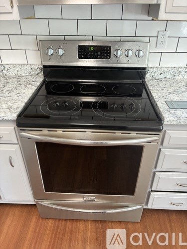 A stainless steel oven with a digital display and control panel is in a kitchen.