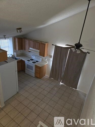 A kitchen with a stove top oven and a fan.
