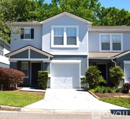 A two-story house with a white garage door in front.