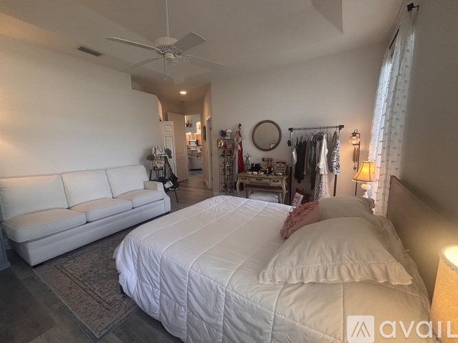A bedroom with a large bed and a white couch.
