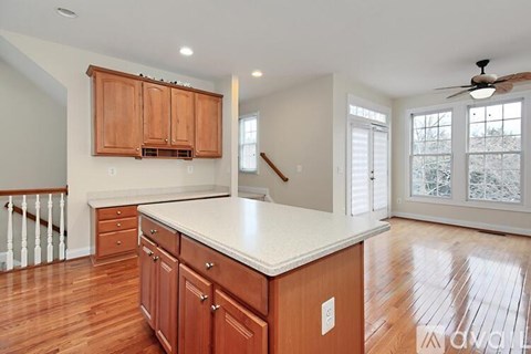 A kitchen with wooden cabinets and a marble countertop.