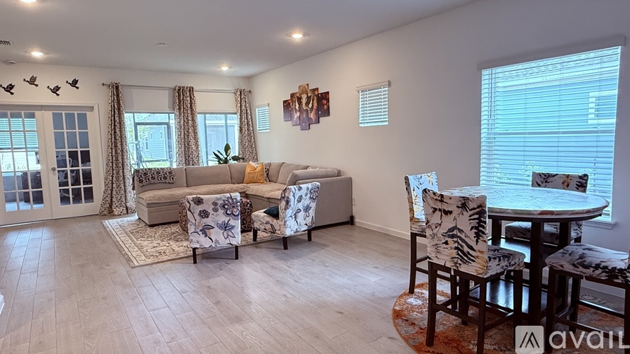 A living room with a sofa, chairs, and a dining table.