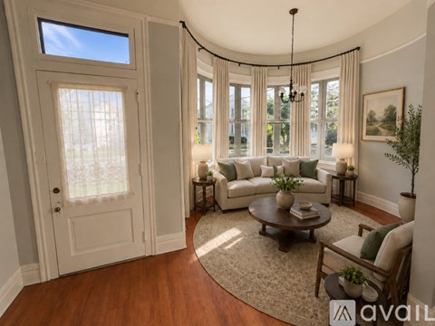 A living room with a large window and a chandelier.