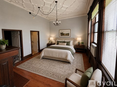 A bedroom with a large bed and a chandelier.