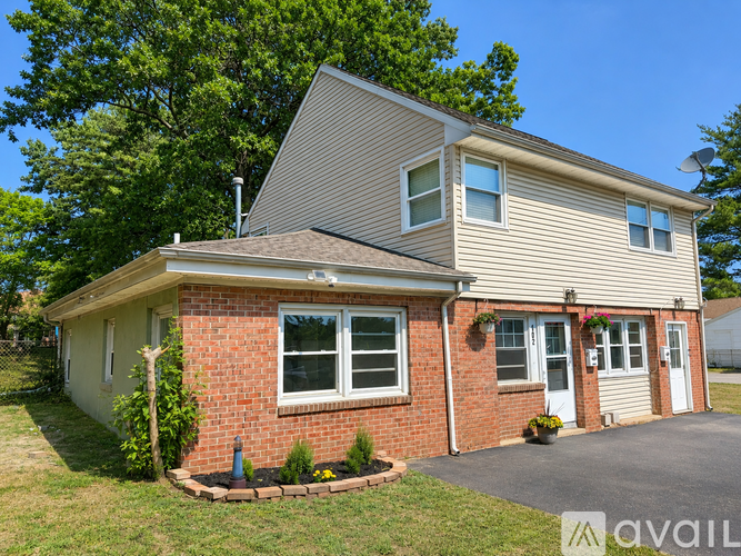 A house with a brick facade and a grey roof is for sale.