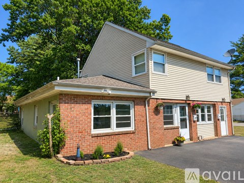 A house with a brick facade and a grey roof is for sale.