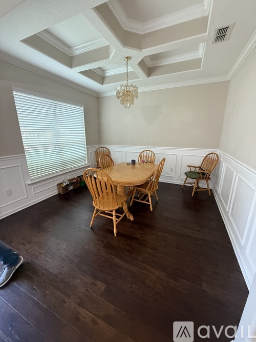 A dining room with a wooden table and chairs.