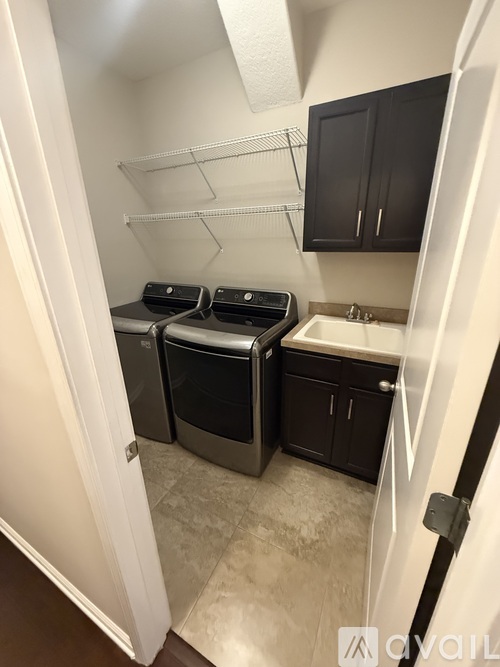 A small kitchen with black cabinets and a white door.