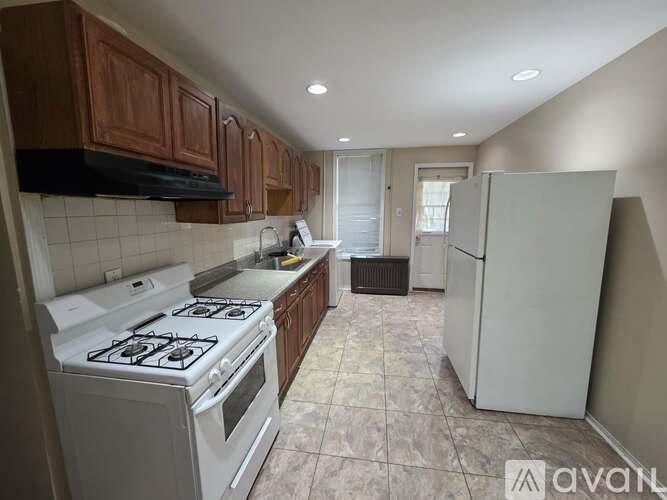 A kitchen with a white stove and a white refrigerator.