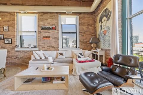 A living room with a brown leather chair and a white couch.