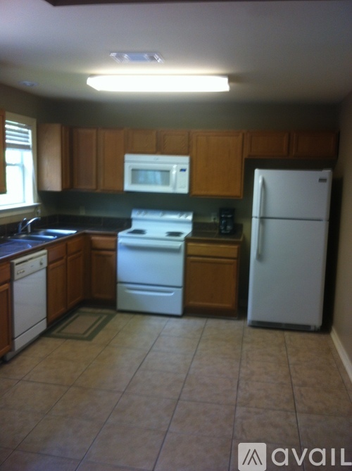 A kitchen with a white refrigerator, white dishwasher, and white microwave.