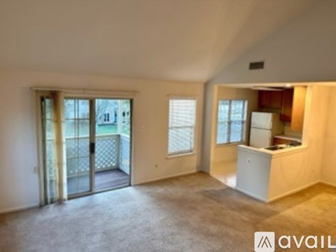 A spacious room with a balcony and a kitchenette.