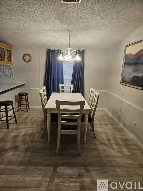 A dining room with a table and chairs.