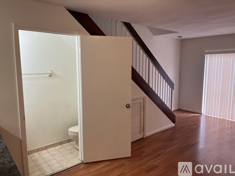 A bathroom with a toilet and a staircase.