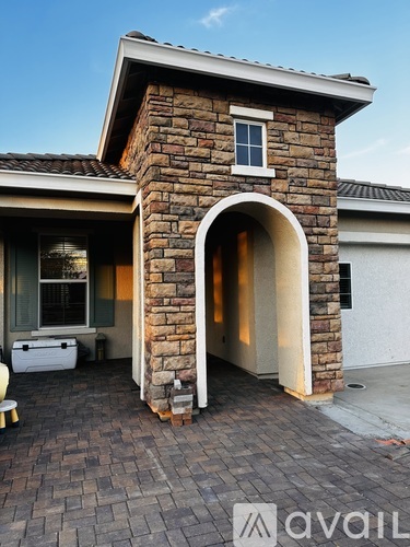A house with a stone pillar and archway entrance.