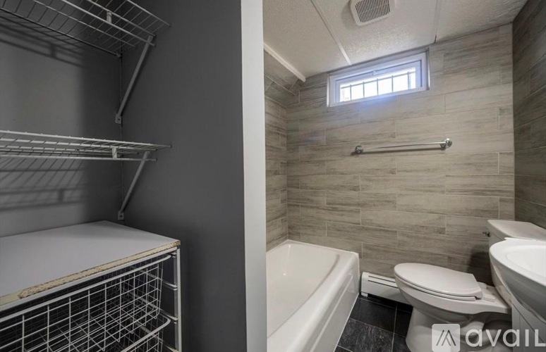 A bathroom with a toilet, tub, and a window.