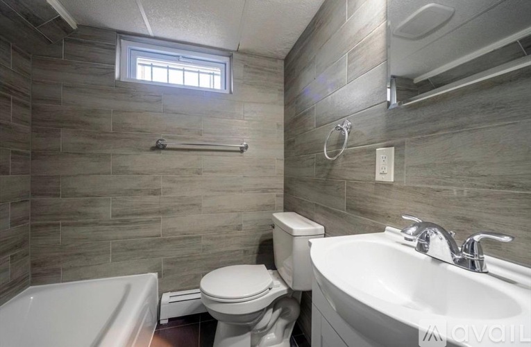 A bathroom with a toilet, sink, and tub.