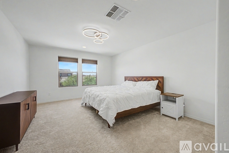 A bedroom with a bed, nightstand, and window.